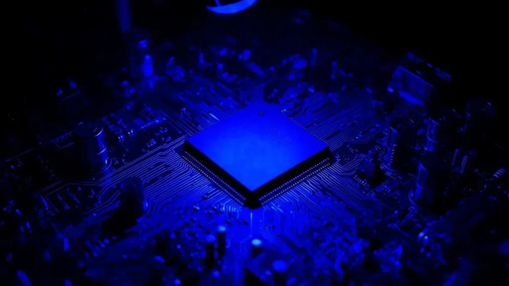 High-angle photo of a fully assembled space-grade avionics circuit board undergoing UV inspection for conformal coating quality